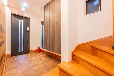 a hallway with wooden stairs and a door at Arashi hotel \u5d50\u30db\u30c6\u30eb in Tokyo