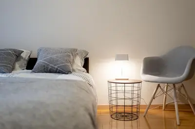 a bedroom with a bed and a chair and a lamp at Belle Lead 105 in Tokyo