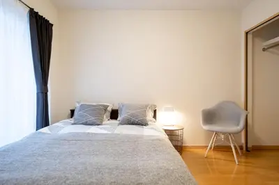 a bedroom with a bed and a chair and a window at Belle Lead 105 in Tokyo