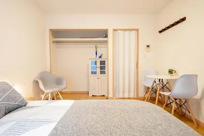 a bedroom with a bed and chairs and a table at Belle Lead 105 in Tokyo