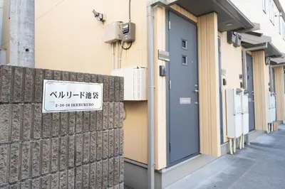 a sign on the side of a building with a blue door at Belle Lead 105 in Tokyo
