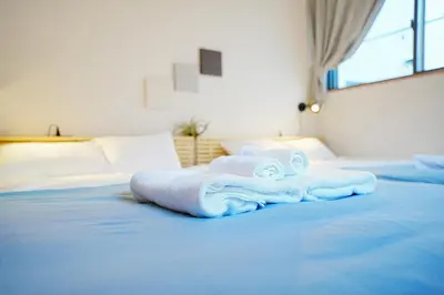 a bed with blue sheets and towels on it at Manere in Tokyo