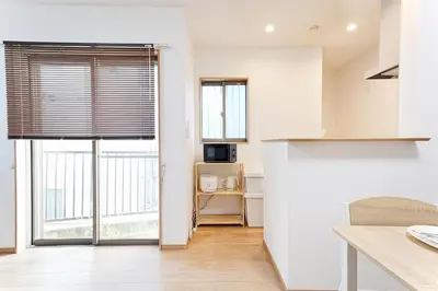 a kitchen with white walls and large windows at Manere in Tokyo