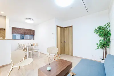 a living room with a blue couch and a table at Manere in Tokyo