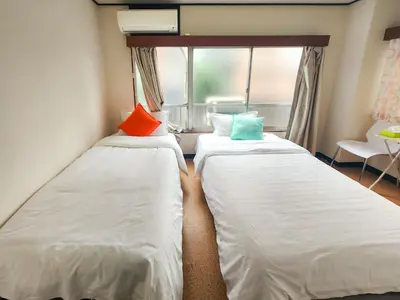 two beds in a small room with a window at Mamada Building - Vacation STAY 18229 in Tokyo