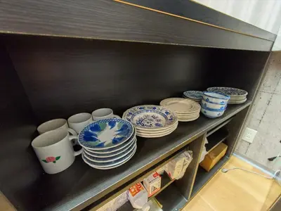 a shelf filled with blue and white plates and cups at Shinbashi Hotel Sho - Vacation STAY 82917v in Tokyo