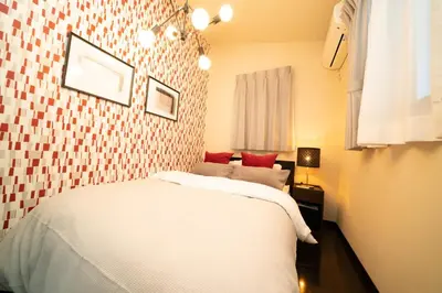 a bedroom with a white bed with red pillows at Hotel Yuga - Vacation STAY 82984v in Tokyo