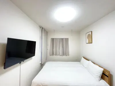 a small room with a bed and a flat screen tv at japan house Otsuka in Tokyo