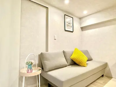 a couch with a yellow pillow in a room at Shinjuku city4\u4eba\u53efTV\u4ed8\u304d in Tokyo