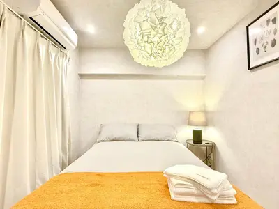 a white bedroom with a bed and a chandelier at Shinjuku city4\u4eba\u53efTV\u4ed8\u304d in Tokyo
