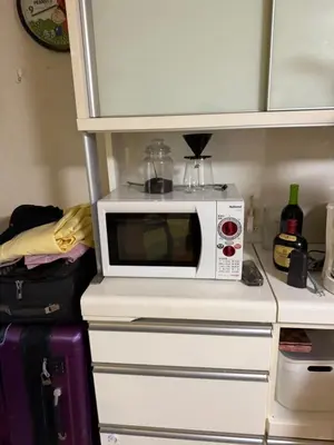 a microwave sitting on top of a kitchen counter at \u7ae5\u7ae5\u6c11\u5bbf in Tokyo