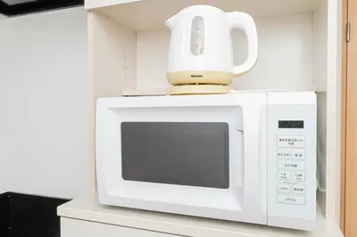 a white microwave with a tea pot on top of it at \u30bb\u30f3\u30c8\u30e9\u30eb\u30d5\u30a3\u30fc\u30eb\u30c9 in Tokyo
