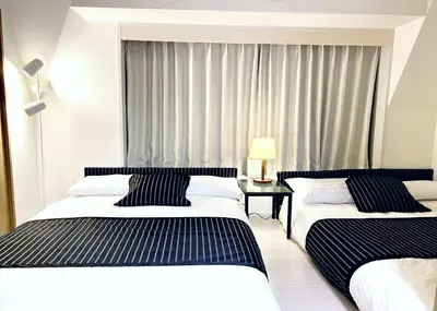 two beds in a hotel room with a window at TOKYO SPA Premier UENO in Tokyo