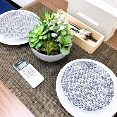 a table with plates and a calculator and a potted plant at TOKYO SPA Premier UENO in Tokyo