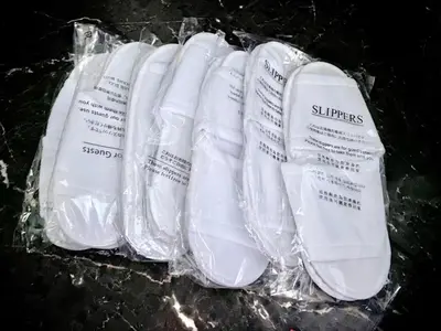 a group of white shoes in plastic bags on a table at TOKYO SPA Premier UENO in Tokyo