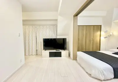 a bedroom with a bed and a flat screen tv at TOKYO SPA Premier UENO in Tokyo