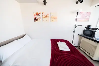 a hotel room with a bed with a microwave at SAKURA Residence\u76ee\u9ed2 301 in Tokyo