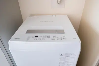 a white washing machine in a small room at SAKURA Residence\u76ee\u9ed2 301 in Tokyo