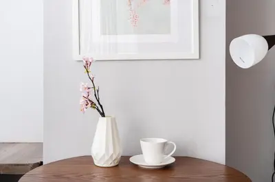 a white vase with flowers and a cup on a table at SAKURA Residence\u76ee\u9ed2 307 in Tokyo