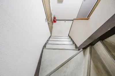 a stair case in a building with a red vase at Fuukanto Kinshicho BNB in Tokyo