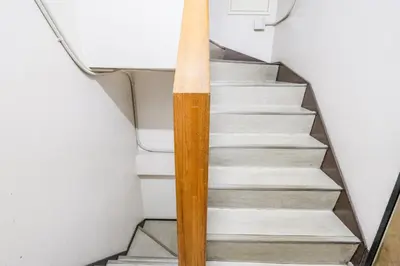 a stairway with a wooden rail next to some stairs at Fuukanto Kinshicho BNB in Tokyo