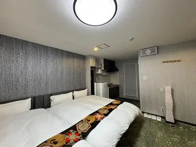a bedroom with a large bed and a lamp at Shiba inn in Tokyo