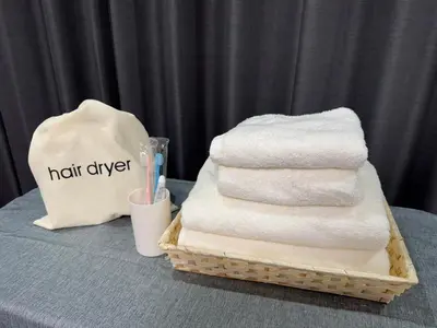 a basket of towels on a table with a cup and a bag at Shiba inn in Tokyo