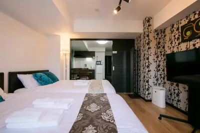 a bedroom with two beds and a flat screen tv at Randor Residence Tokyo Annex in Tokyo