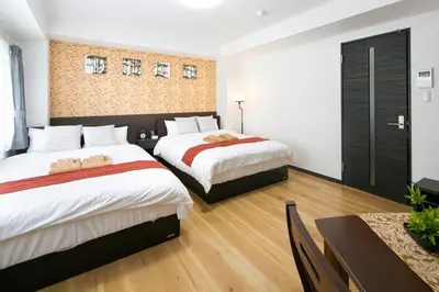 a hotel room with two beds and a table at Randor Residence Tokyo Annex in Tokyo