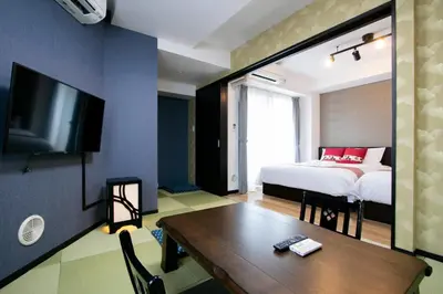 a bedroom with a bed and a table and a tv at Randor Residence Tokyo Annex in Tokyo