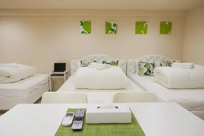 a room with two white beds with remote controls at Avinity Higashi Nakano 1F - Vacation STAY 87308v in Tokyo