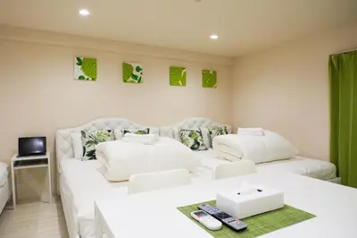 a living room with two white beds and a tv at Avinity Higashi Nakano 1F - Vacation STAY 87308v in Tokyo
