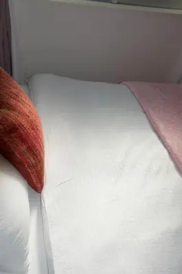 a white bed with a red pillow on it at \u5168\u65b0\u88c5\u4fee\u5357\u54c1\u5dddHaven\u67091\u95f4\u548c\u5ba4\u51712\u5367\u5ba4 in Tokyo