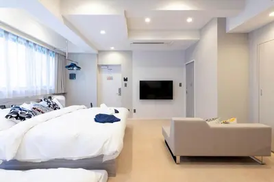a bedroom with a bed and a couch and a tv at ENT TERRACE GINZA Premium in Tokyo