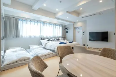 a room with two beds and a table and chairs at ENT TERRACE GINZA Premium in Tokyo