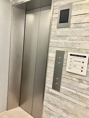 an elevator in a building with a stone wall at ENT TERRACE GINZA Premium in Tokyo