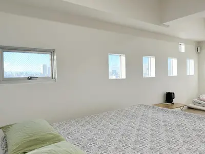 a white room with a bed and a window at Shinjuku Kabuki Youth Hostel#New Sunshine Room#50 second walk from Higashi Shinjuku subway#Automatic locking door at entrance#\u65b0\u5bbf1 in Tokyo