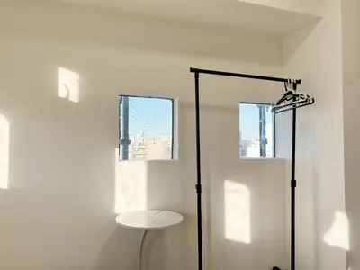 a white room with a table and two windows at Shinjuku Kabuki Youth Hostel#New Sunshine Room#50 second walk from Higashi Shinjuku subway#Automatic locking door at entrance#\u65b0\u5bbf1 in Tokyo