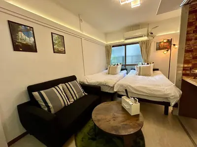 a room with two beds and a chair and a table at Cozy Residential Retreat! Easy Access to Ikebukuro & Shinjuku in Tokyo