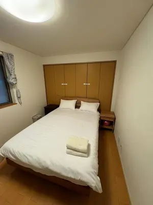 a bedroom with a large white bed with a towel on it at PUSU-OKUBO House 3LDK-SJ0079 in Tokyo