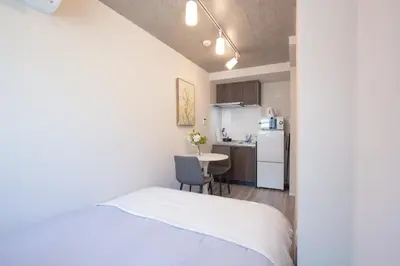 a small room with a bed and a kitchen at \u6771\u4e0a\u91ce\u306e\u96a0\u308c\u5bb6 \u4e0a\u91ce\u99c5\u5f92\u6b69\u570f\u5185\u306e\u30a2\u30c3\u30c8\u30db\u30fc\u30e0\u306a\u5bbf EoE6 SioE in Tokyo