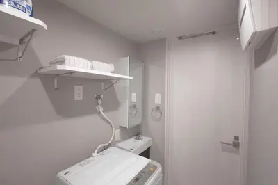 a bathroom with a washing machine and a mirror at \u6771\u4e0a\u91ce\u306e\u96a0\u308c\u5bb6 \u4e0a\u91ce\u99c5\u5f92\u6b69\u570f\u5185\u306e\u30a2\u30c3\u30c8\u30db\u30fc\u30e0\u306a\u5bbf EoE6 SioE in Tokyo