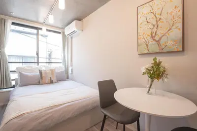 a small bedroom with a bed and a table at \u6771\u4e0a\u91ce\u306e\u96a0\u308c\u5bb6 \u4e0a\u91ce\u99c5\u5f92\u6b69\u570f\u5185\u306e\u30a2\u30c3\u30c8\u30db\u30fc\u30e0\u306a\u5bbf EoE6 SioE in Tokyo