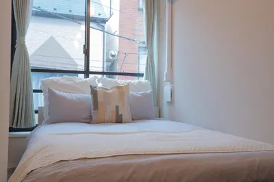 a bed in a room with a large window at \u6771\u4e0a\u91ce\u306e\u96a0\u308c\u5bb6 \u4e0a\u91ce\u99c5\u5f92\u6b69\u570f\u5185\u306e\u30a2\u30c3\u30c8\u30db\u30fc\u30e0\u306a\u5bbf EoE6 SioE in Tokyo