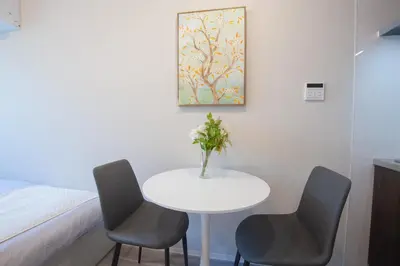 a room with a table and two chairs and a bed at \u6771\u4e0a\u91ce\u306e\u96a0\u308c\u5bb6 \u4e0a\u91ce\u99c5\u5f92\u6b69\u570f\u5185\u306e\u30a2\u30c3\u30c8\u30db\u30fc\u30e0\u306a\u5bbf EoE6 SioE in Tokyo