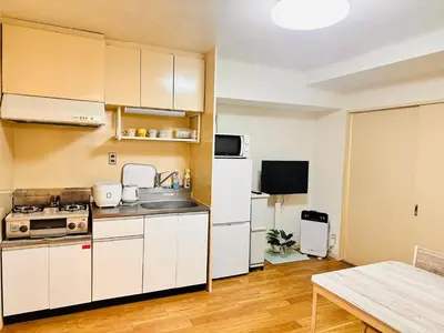 a kitchen with white cabinets and a sink and a table at Ikebukuro\u4e2d\u5ddd5E -TS0036 in Tokyo