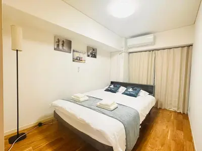 a bedroom with a bed with white sheets and blue pillows at Ikebukuro\u4e2d\u5ddd5E -TS0036 in Tokyo