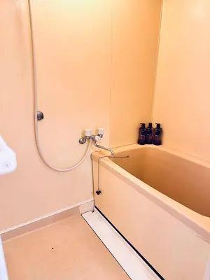 a bathroom with a bathtub with a hose on the wall at Ikebukuro\u4e2d\u5ddd5E -TS0036 in Tokyo