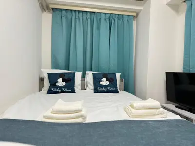 a bedroom with a bed with pillows and a tv at Top Ikebukuro 301 -TS0034 in Tokyo
