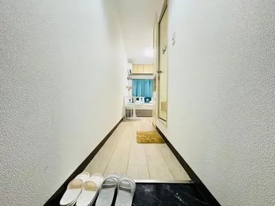 a hallway with white walls and a row of slippers at Top Ikebukuro 301 -TS0034 in Tokyo